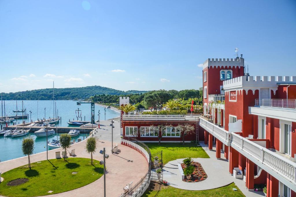 vista su un porto turistico con un edificio rosso di Hotel Villa Garuti a Padenghe sul Garda