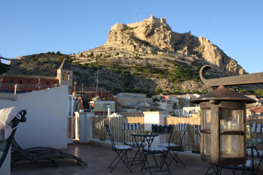 a balcony with tables and chairs and a mountain at Santa Barbara Guesthouse in Alicante