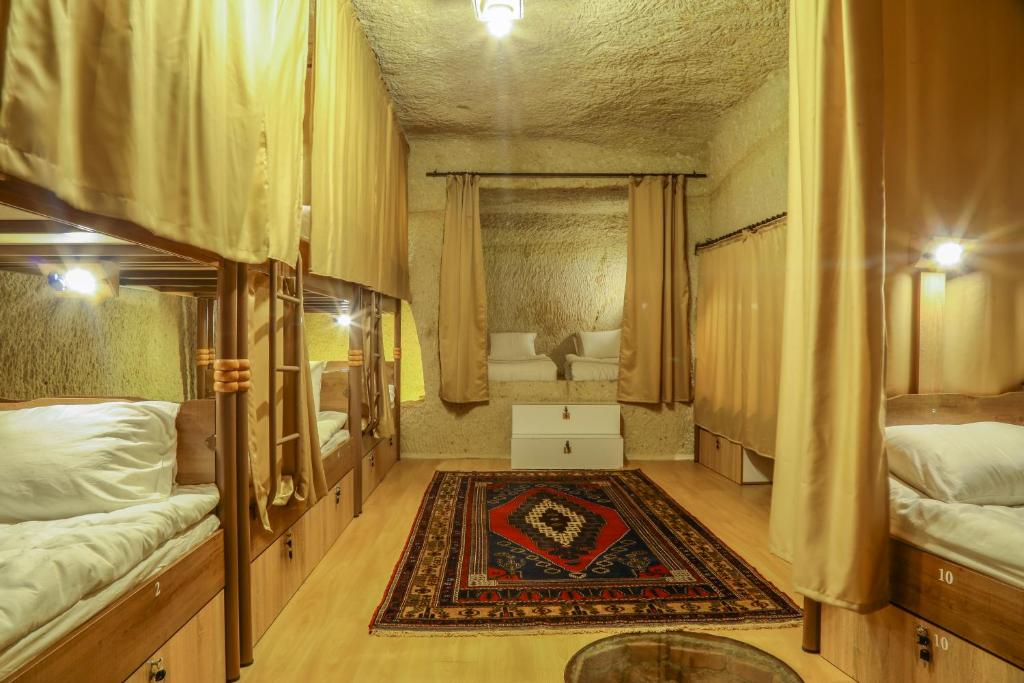 a room with a bed, a chair, and a window at Homestay Cave Hostel in Goreme