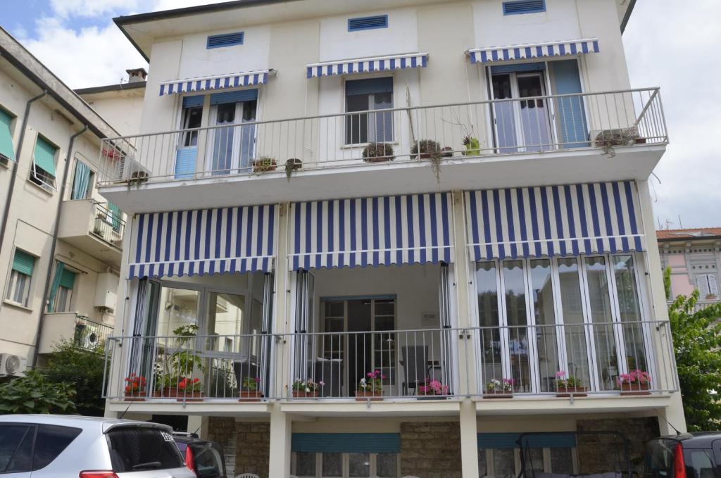 un edificio blanco con balcones y flores. en Affittacamere La Zattera, en Lido di Camaiore