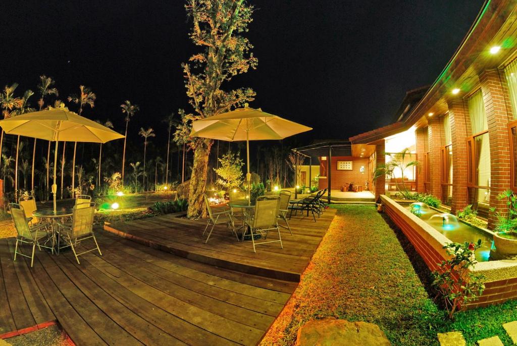 a wooden deck with chairs and umbrellas at night at TFG B&amp;B in Lugu Lake