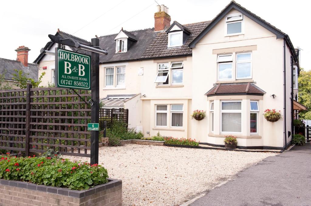 een huis met een bord ervoor bij Holbrook Bed and Breakfast in Shaftesbury