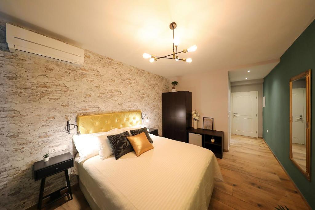 a bedroom with a bed and a brick wall at Aldo Apartments Center in Zadar