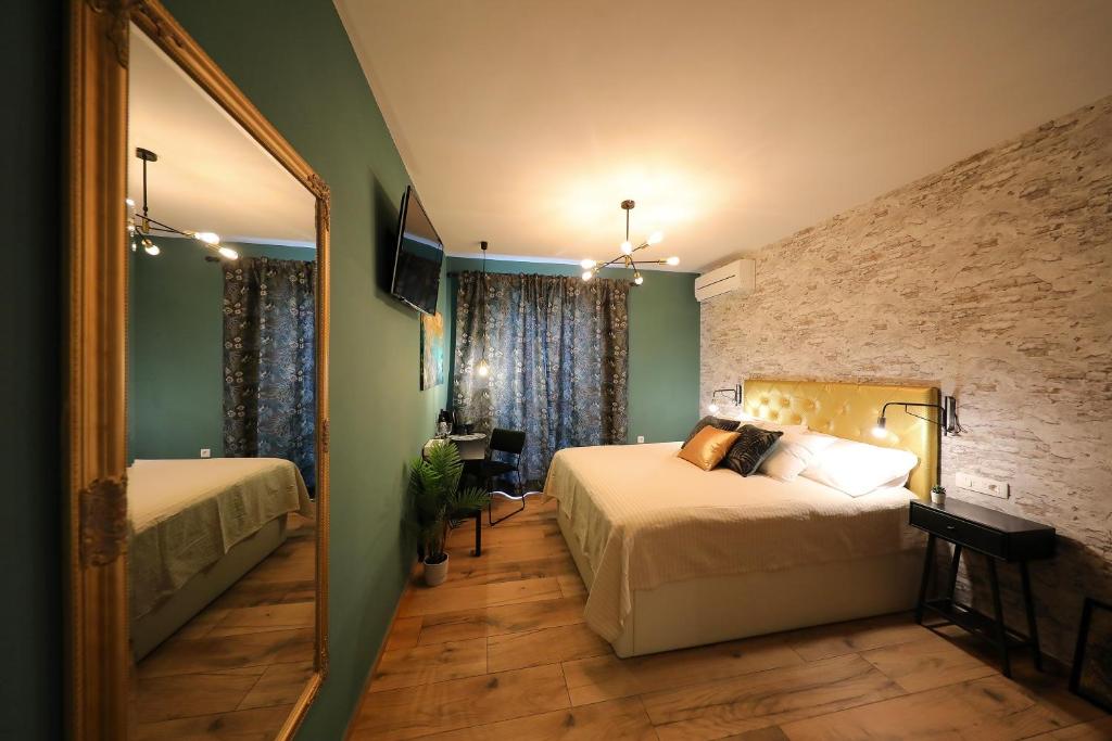 a bedroom with two beds and a mirror at Aldo Apartments Center in Zadar