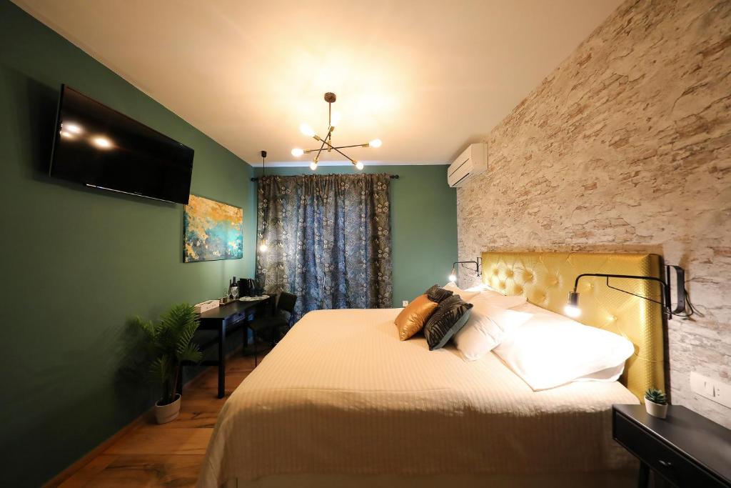 a bedroom with a bed with a television and a desk at Aldo Apartments Center in Zadar