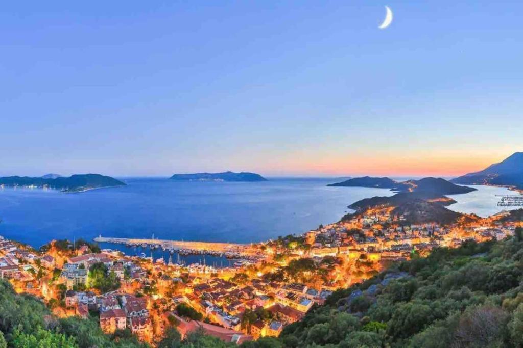 vista para uma cidade e para o oceano ao anoitecer em Begonya Suites em Kas