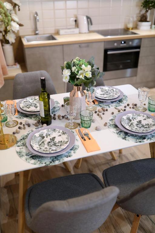 a table with plates and glasses and a bottle of wine at Aldo Apartments Center in Zadar