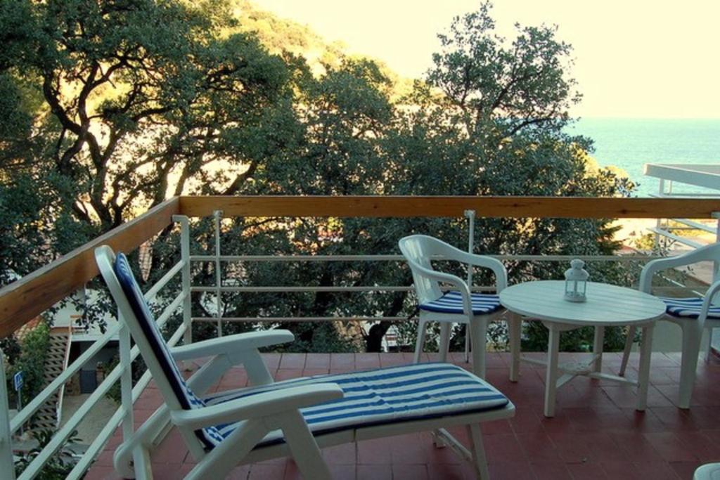 un patio con sillas y una mesa en una terraza en Ma terrasse à la mer - Holiday apartment, en Tossa de Mar