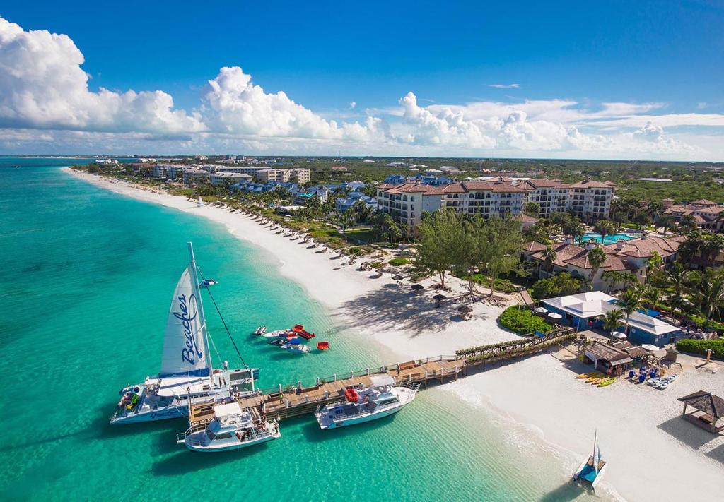 Beaches Turks and Caicos Resort Villages and Spa All Inclusive في بروفيدنسياليس: اطلالة جوية على شاطئ فيه قوارب في الماء