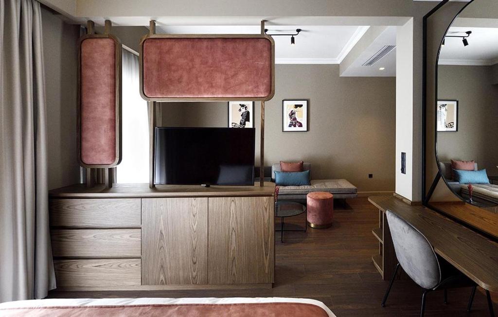 sypialnia z telewizorem i dużym lustrem w obiekcie Roomore Apartments w Salonikach