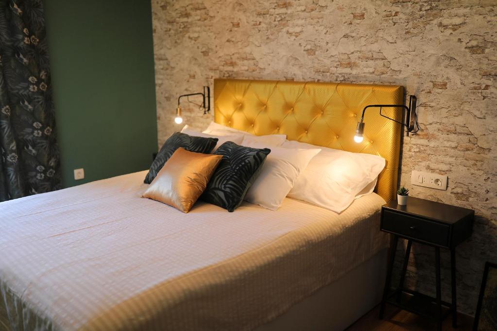 a bedroom with a bed with a yellow headboard and pillows at Aldo Apartments Center in Zadar