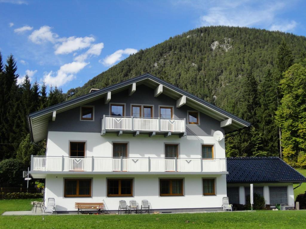 a large white building with a mountain in the background at Gästehaus Bergrast in Schladming