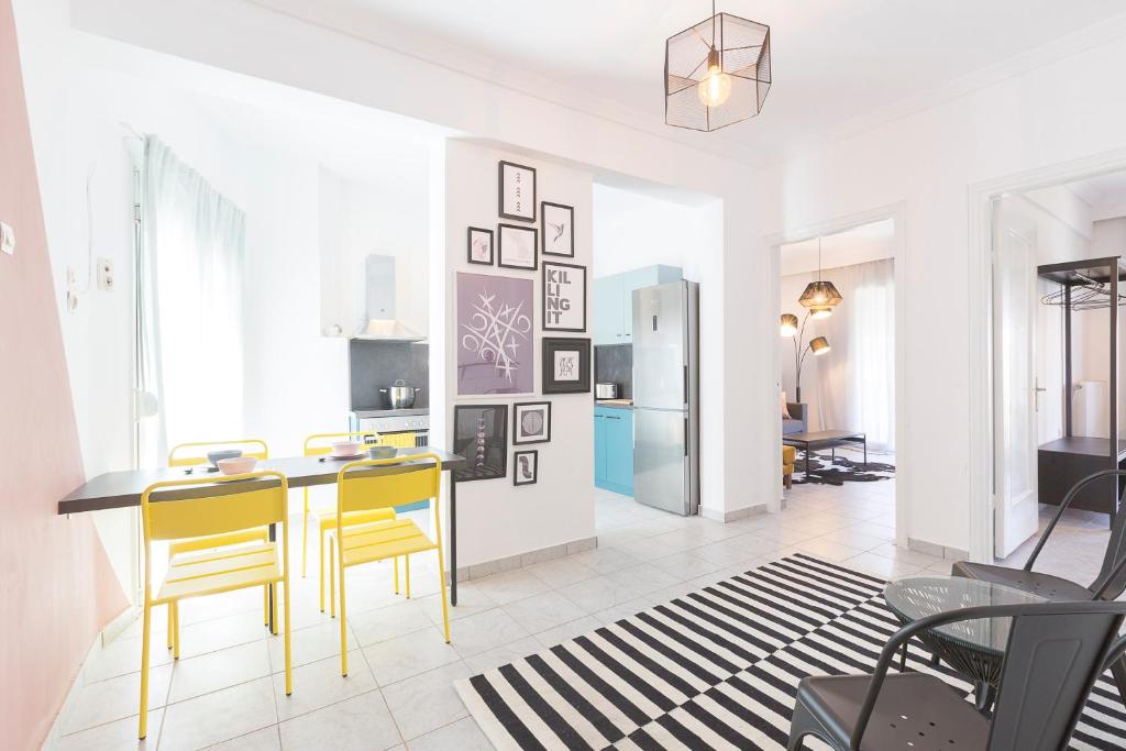 a kitchen with a table and yellow chairs in a room at #FLH - Belle Reve Apartment in Thessaloniki