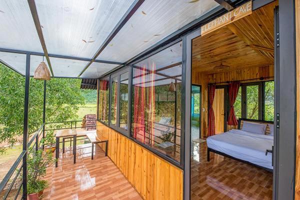 une maison avec une chambre et un lit sur une terrasse couverte dans l'établissement Jungle Boss Homestay, à Phong Nha