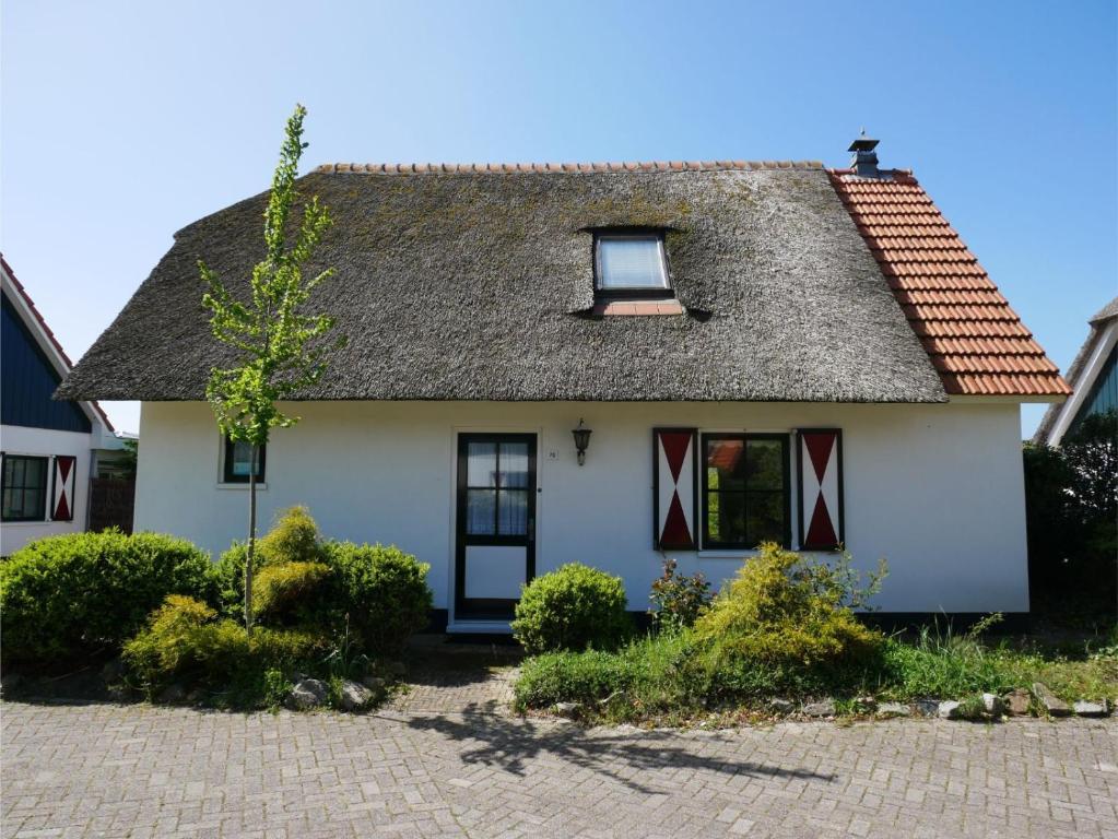 a white house with a gray roof at Buitenplaats Villa 5-p in Callantsoog