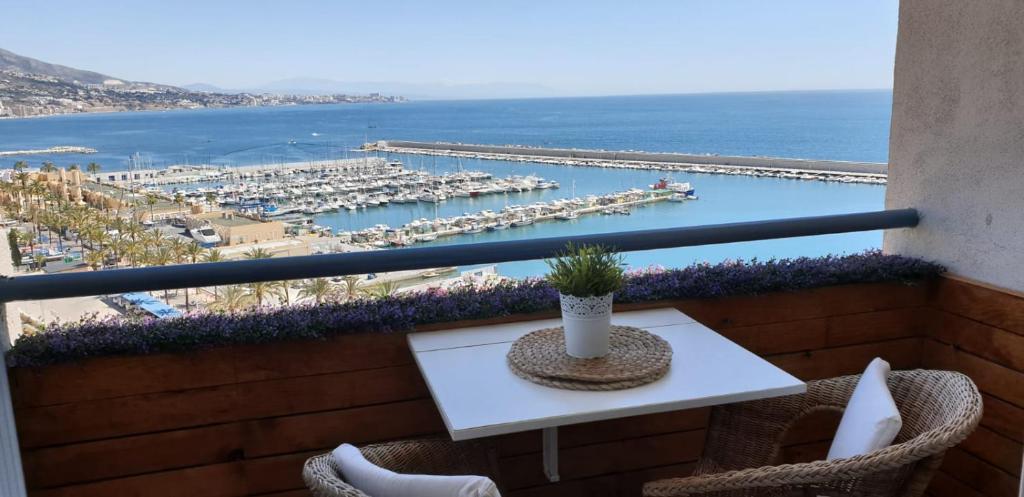 een balkon met een tafel en uitzicht op een jachthaven bij ESTUDIO SOLYPLAYARELAX in Fuengirola