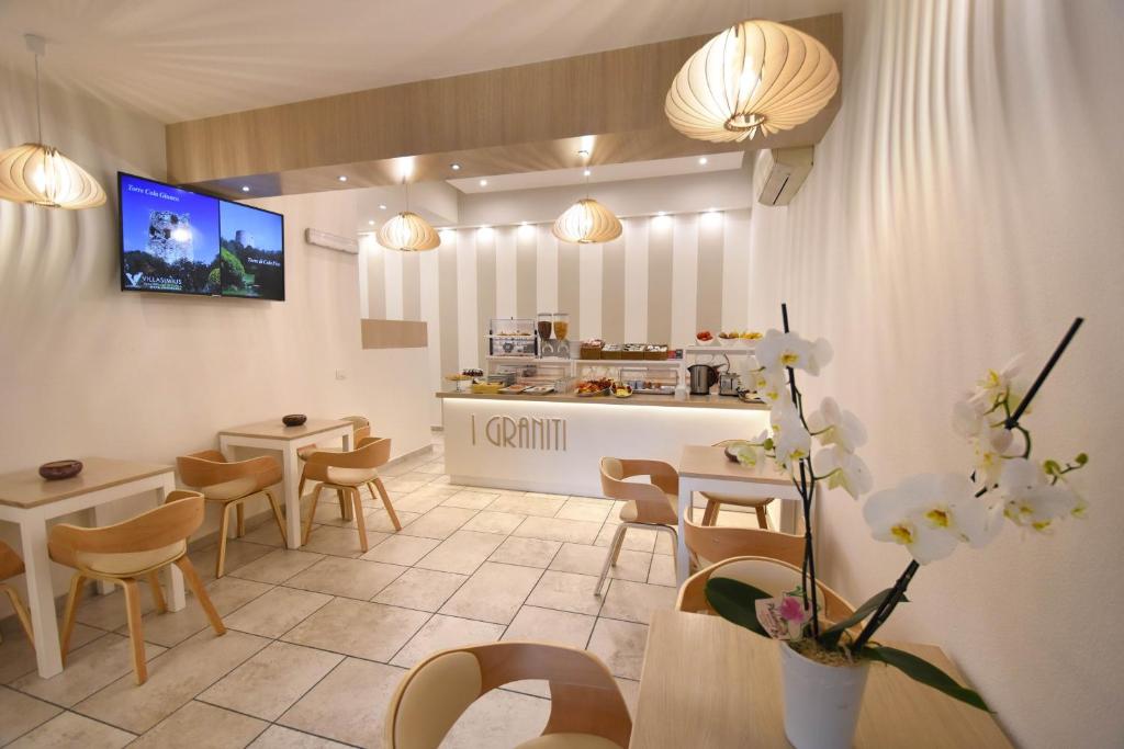 a kitchen with a table and chairs and a tv at Hotel I Graniti in Villasimius
