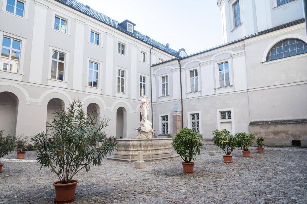 
a large stone building with a statue of a man in front of it at Gästehaus im Priesterseminar Salzburg in Salzburg
