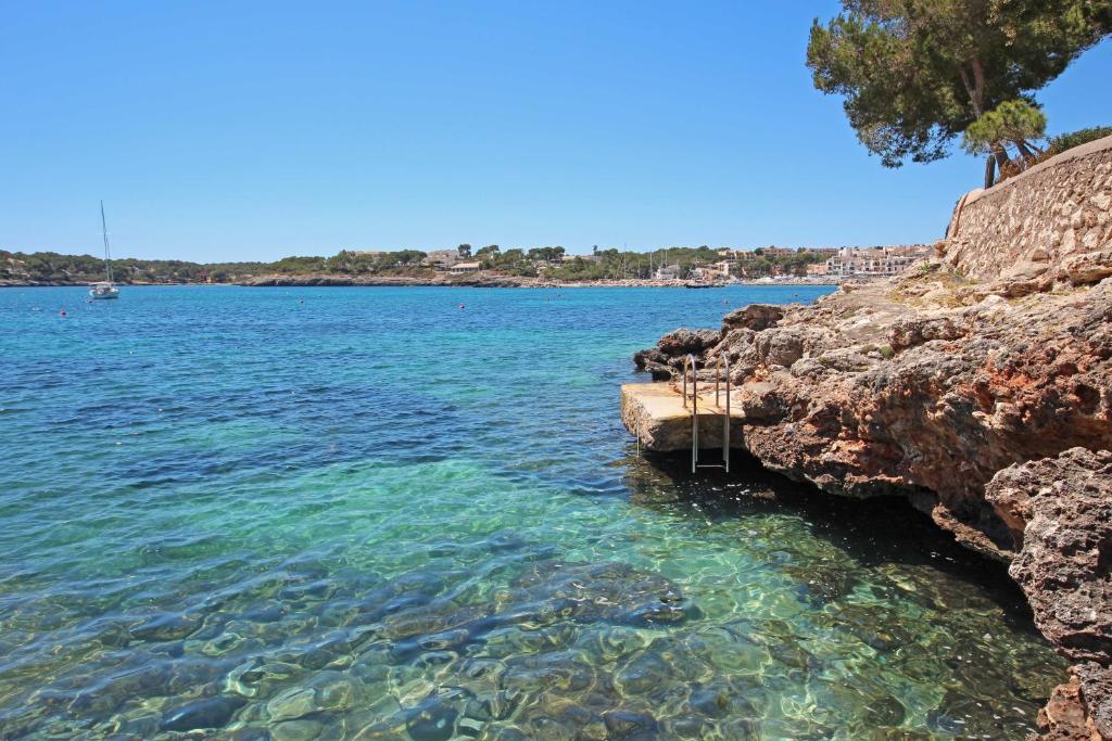 a view of the water from a rocky shore at Aparthotel Niu d´Aus in Portopetro