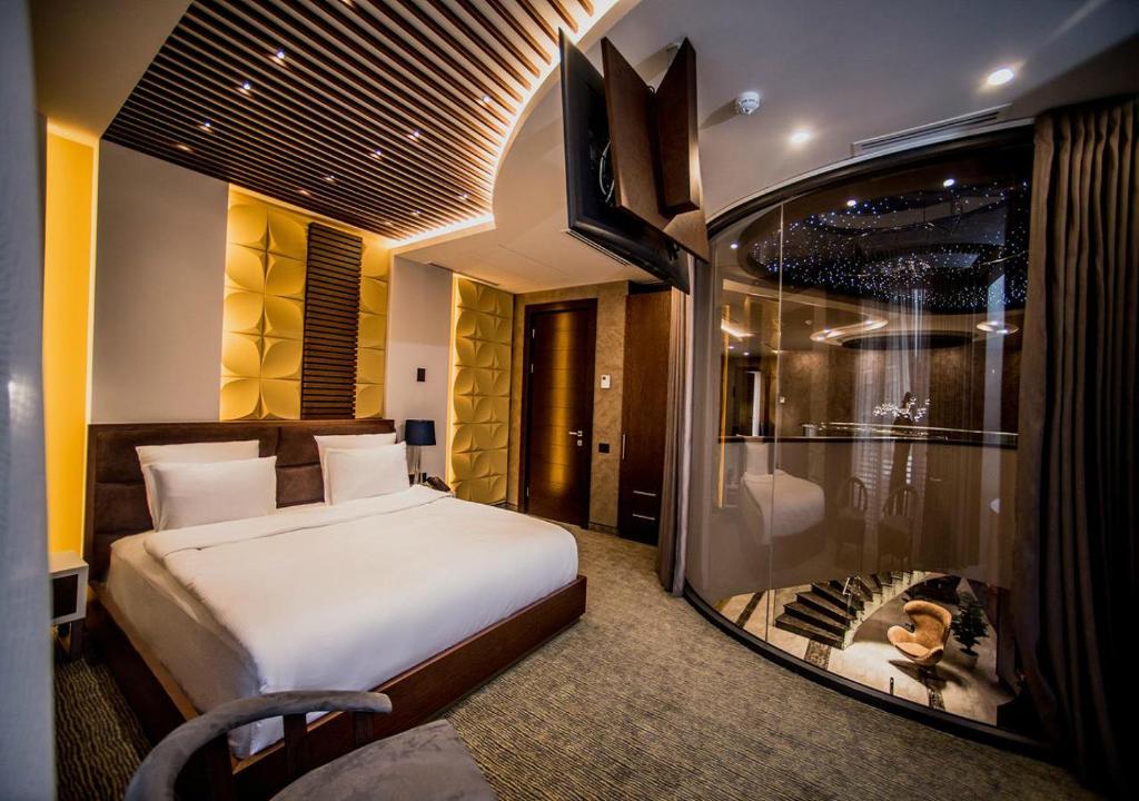 um quarto de hotel com uma cama e uma parede de vidro em Aghababyan's Hotel em Yerevan