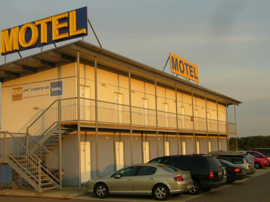 a mobil gas station with cars parked in a parking lot at Tour-Motel in Wilfersdorf