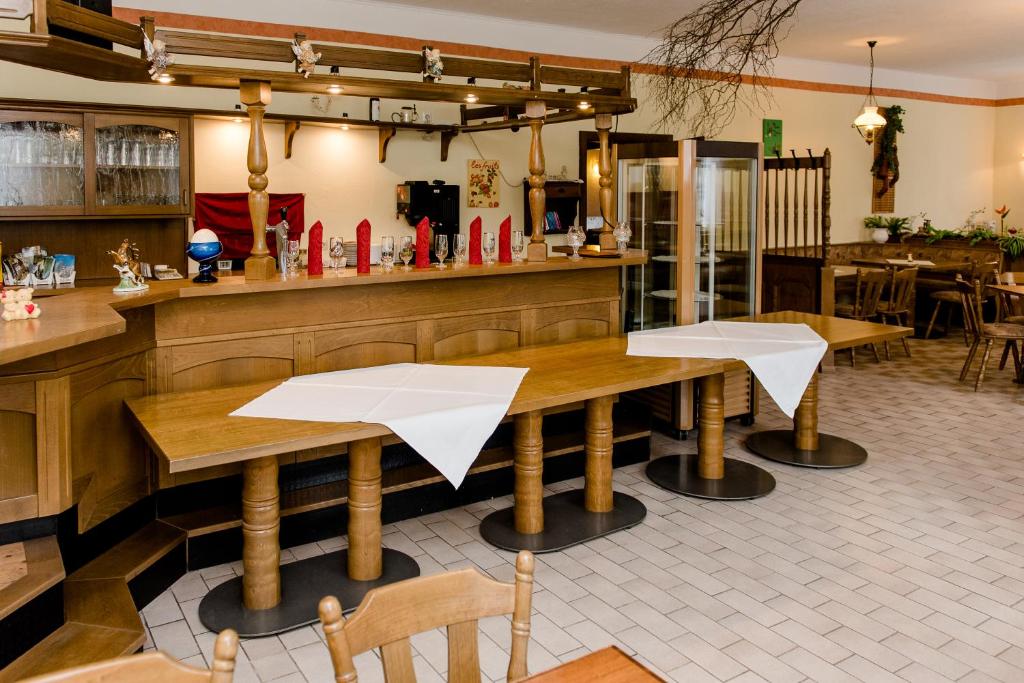 ein Restaurant mit Holztischen und einer Bar in der Unterkunft Hotel und Campingstell und Zeltplatz an der Talsperre im Harz in Altenbrak