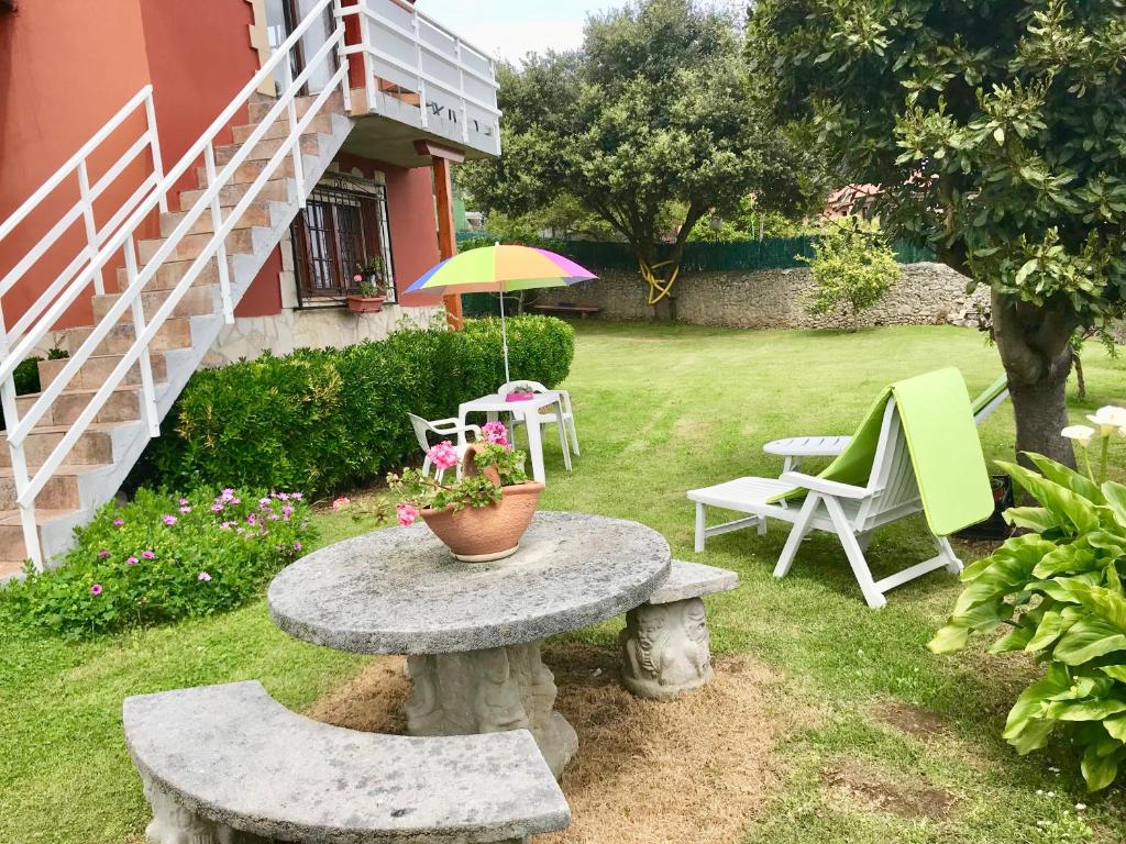 a patio with a table and chairs and an umbrella at Estudio de encanto en Isla playa in Arnuero