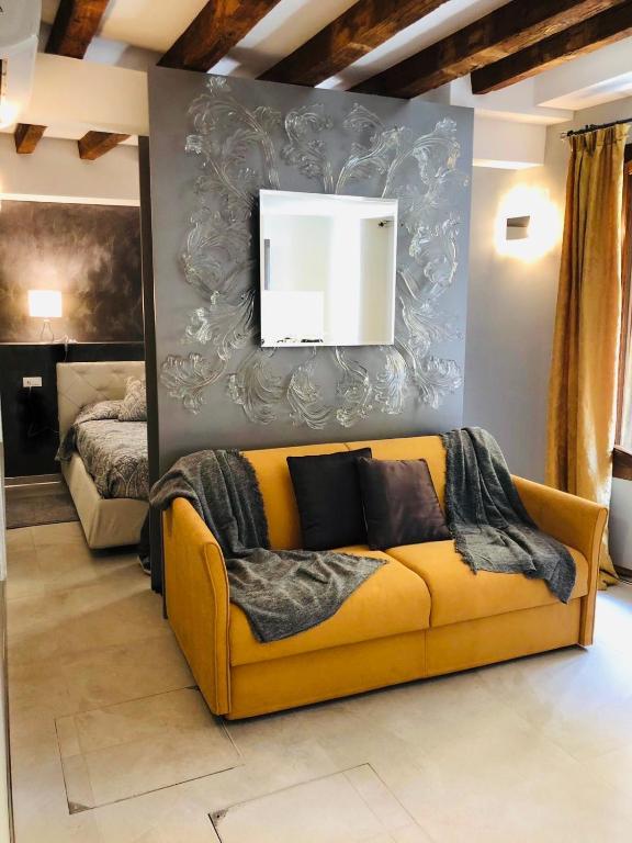 salon z żółtą kanapą przed ścianą w obiekcie Suite Dream on the River w Wenecji