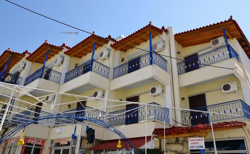ein Gebäude mit blauen Balkonen auf der Seite in der Unterkunft KOTSIFAS ROOMS in Tiros