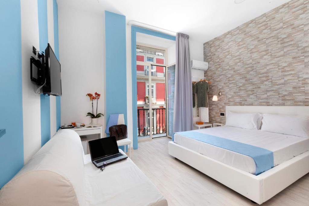 - une chambre avec un lit et un ordinateur portable sur un canapé dans l'établissement Rainbow Napoli, à Naples