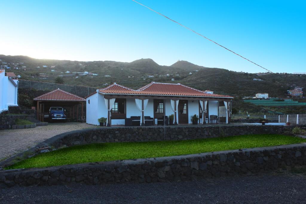 una casa con una pared de piedra delante de ella en Mama Yé, en Lodero