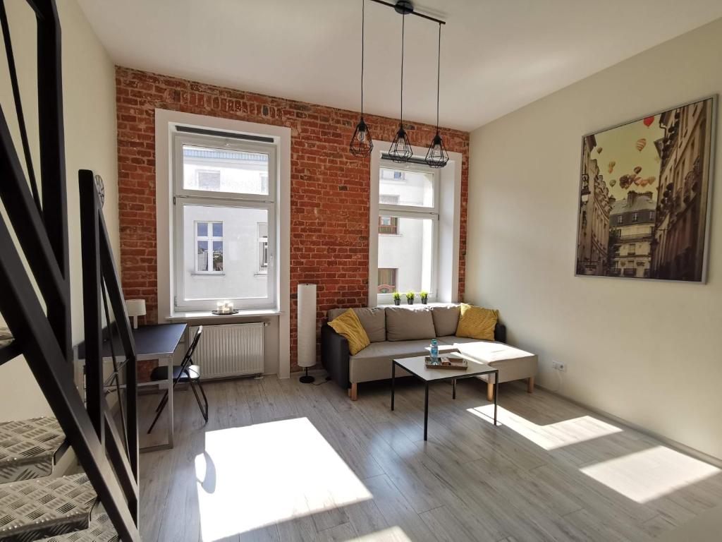 - un salon avec un canapé et un mur en briques dans l'établissement Klimatyczny apartament w magicznym miejscu, à Łódź
