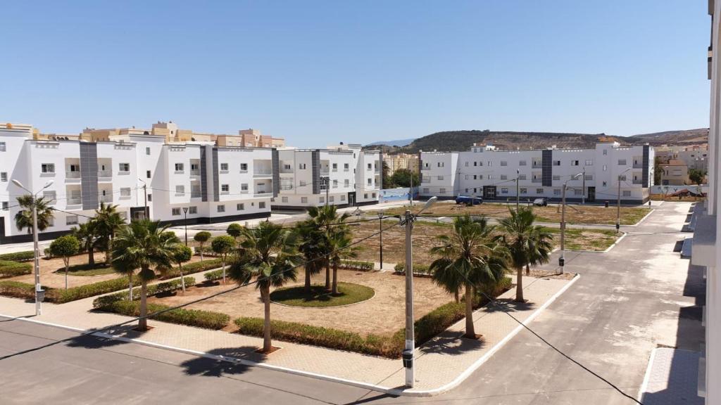 une rue vide avec des palmiers et des bâtiments dans l'établissement Appartement cocooning à saidia proche toutes commodités, à Saïdia