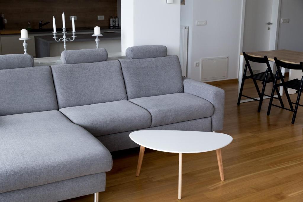 a living room with a gray couch and a table at Auredius Deluxe Sea Apartment in Koper