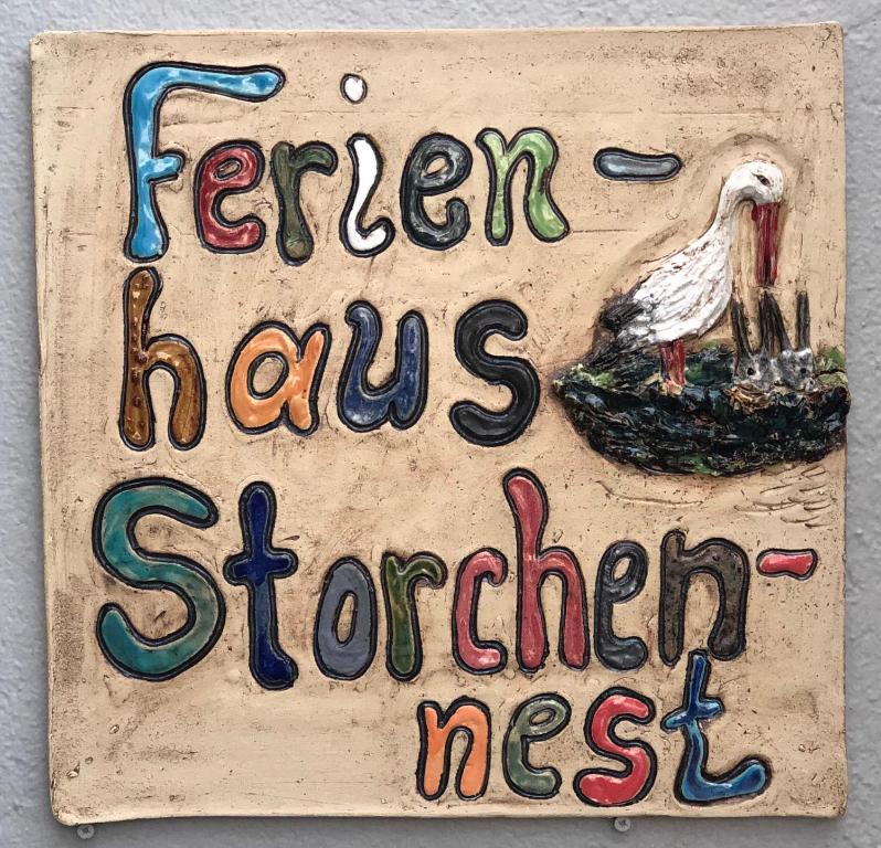 Ein Zeichen mit einem Vogel drauf mit den Worten, die Henne hat brüderlich in der Unterkunft Ferienhaus Storchennest in Pleinfeld