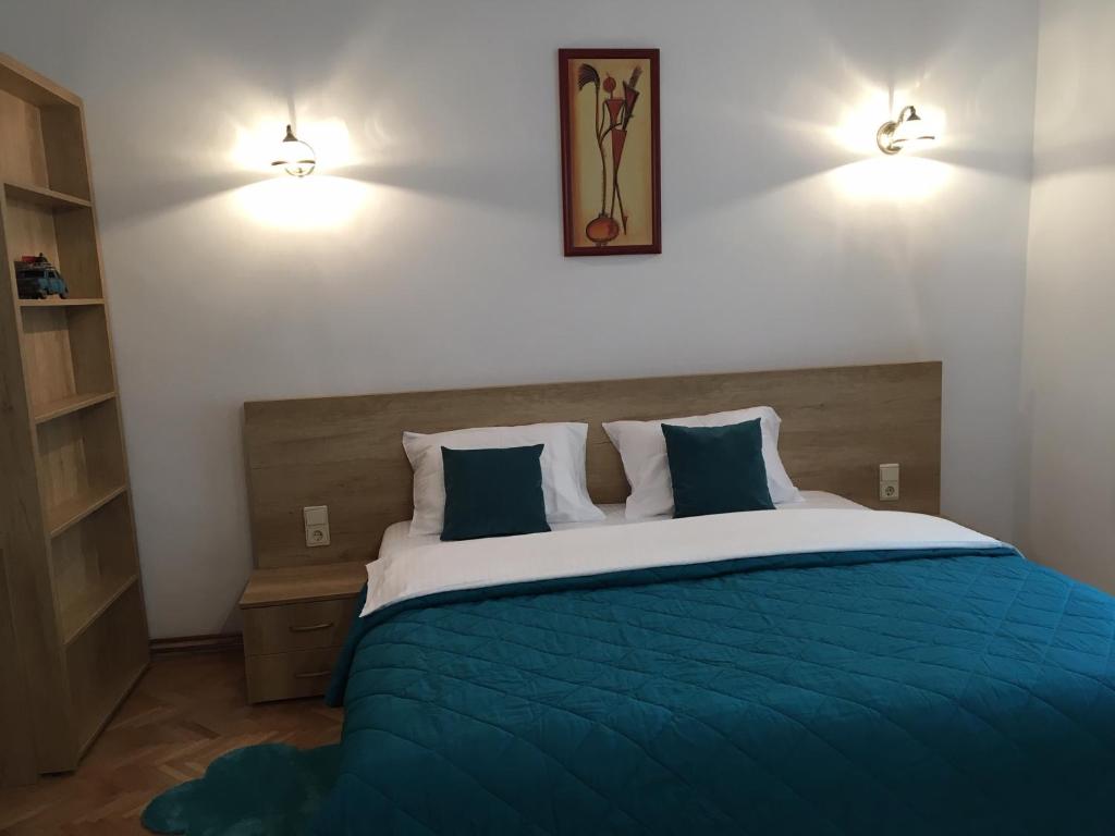 una camera da letto con un letto grande con lenzuola blu di Central House Morariu a Sibiu
