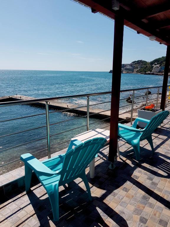 two chairs and a table on a deck overlooking the ocean at Summer Holiday House MM in Ulcinj