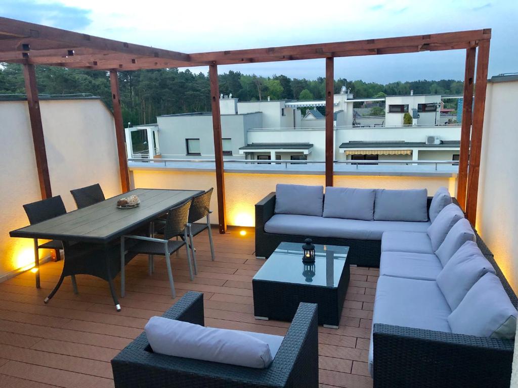 patio z kanapą i stołem na dachu w obiekcie Jantar w mieście Jantar