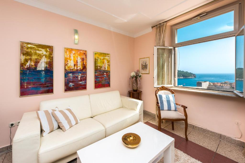 a living room with a white couch and a window at Apartment Green Oasis in Dubrovnik