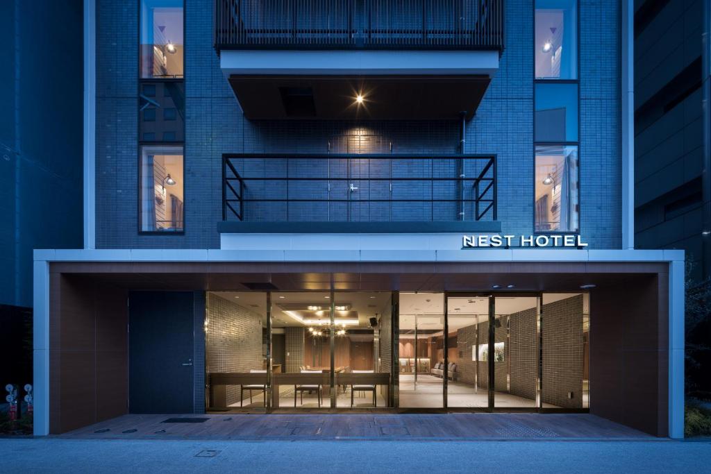 a building with a first hotel entrance at night at Nest Hotel Hiroshima Hatchobori in Hiroshima