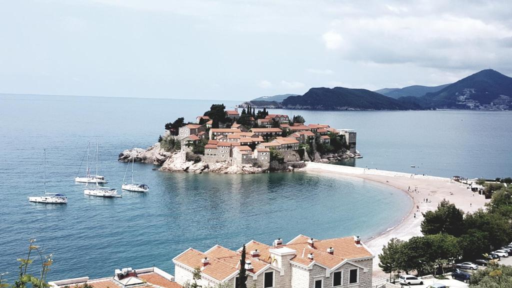 a small island with houses and boats in the water at Guest House Ivo Jovanovic in Sveti Stefan