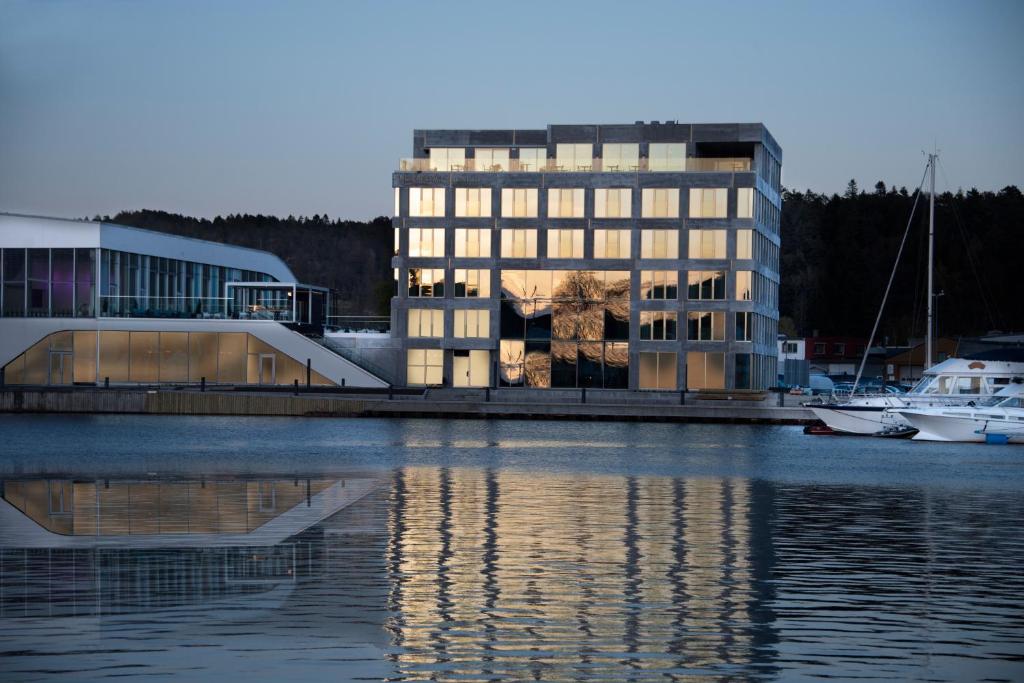 a large building next to a body of water at Mandal Hotel in Mandal