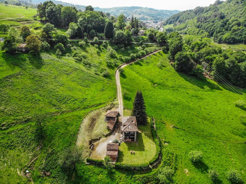 ein altes Haus mitten auf einem grünen Feld in der Unterkunft Finca La Casería LA CASA in Cangas de Onís