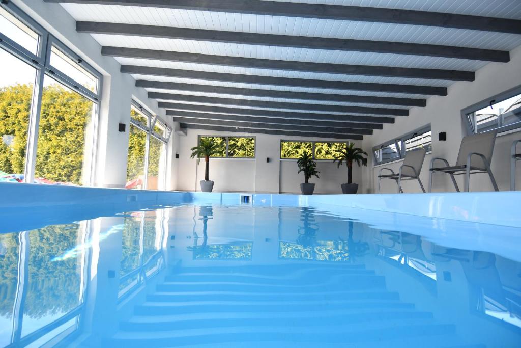 a swimming pool with blue water and windows at Villa Altair4kids in Władysławowo