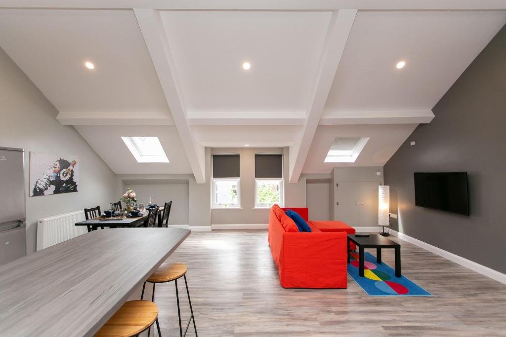 a living room with a red couch and a table at University Road Apartments in Belfast