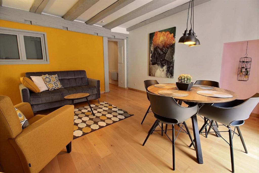 - un salon avec une table et un canapé dans l'établissement LE PTIT BARTHO, à Colmar