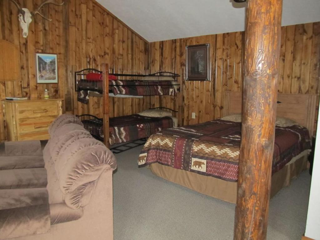 a bedroom with two bunk beds and a couch at The Remington Cabin in Wapiti