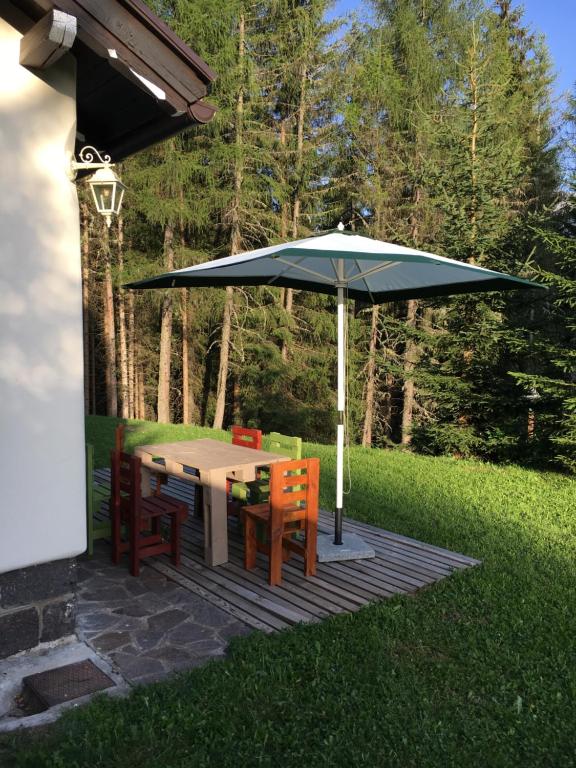 stół i krzesła pod parasolem na patio w obiekcie il Finferlo w mieście Bellamonte