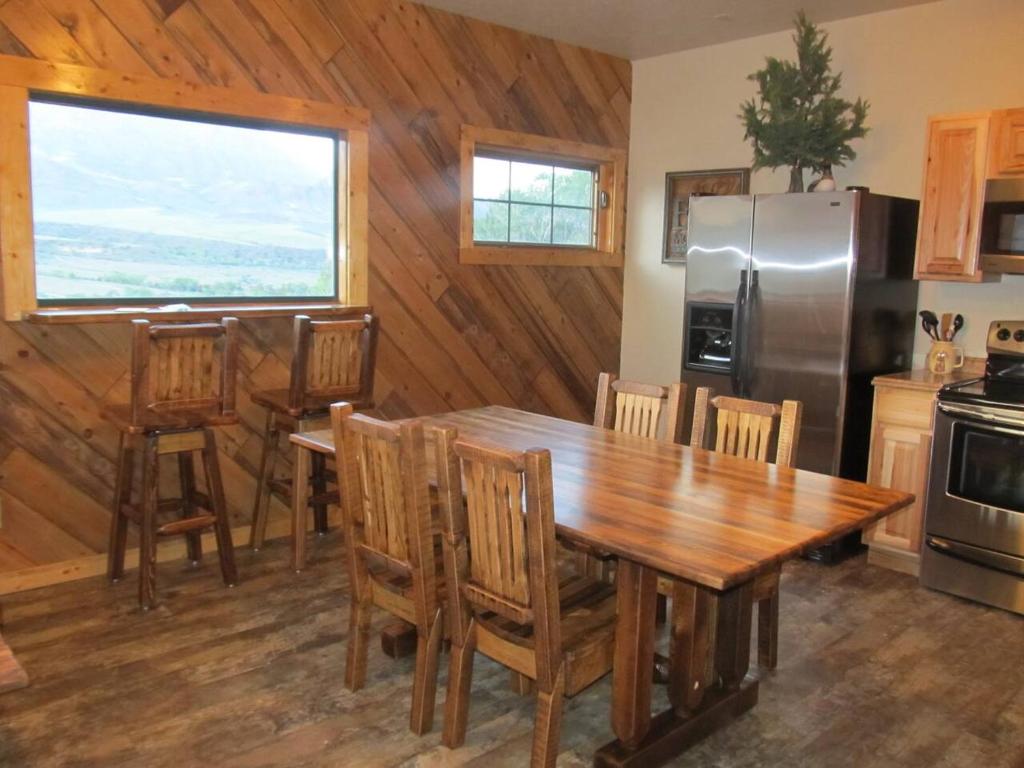 a kitchen with a wooden table and a refrigerator at Mountain Man Cabin in Wapiti