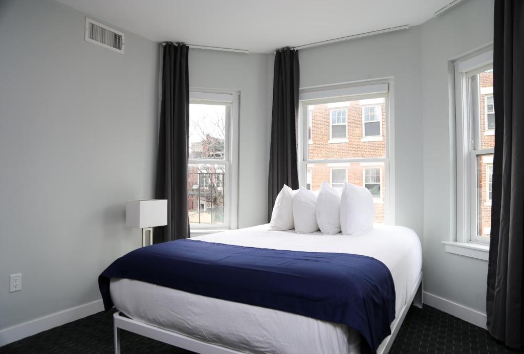 1 dormitorio con 1 cama grande y 2 ventanas en Stylish Studio on Newbury Street, #10, en Boston